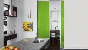 Glasschiebetüren als Raumteiler zwischen Küche und Wohnraum.